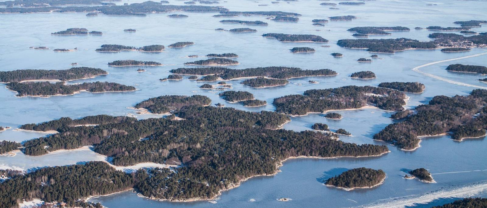 The Stockholm archipelago from the air in winter, islands held in sea ice.